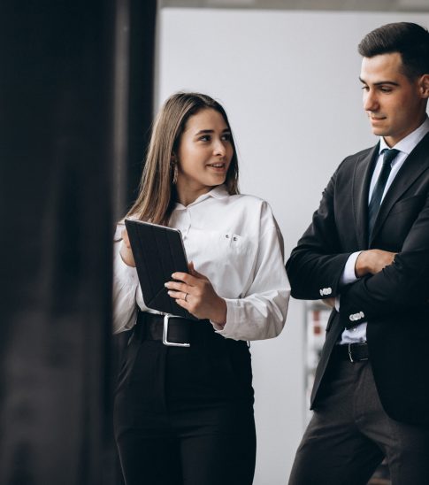 Male and female business people working on tablet in office